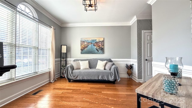 living area featuring crown molding and hardwood / wood-style flooring