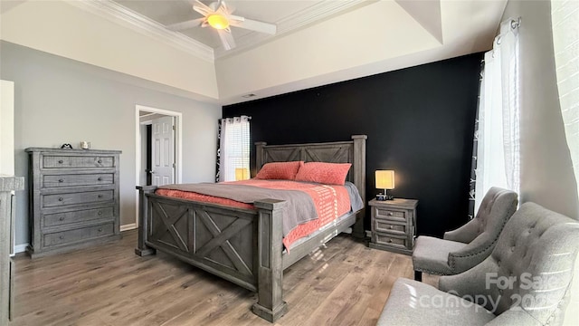 bedroom featuring wood-type flooring, ornamental molding, and ceiling fan