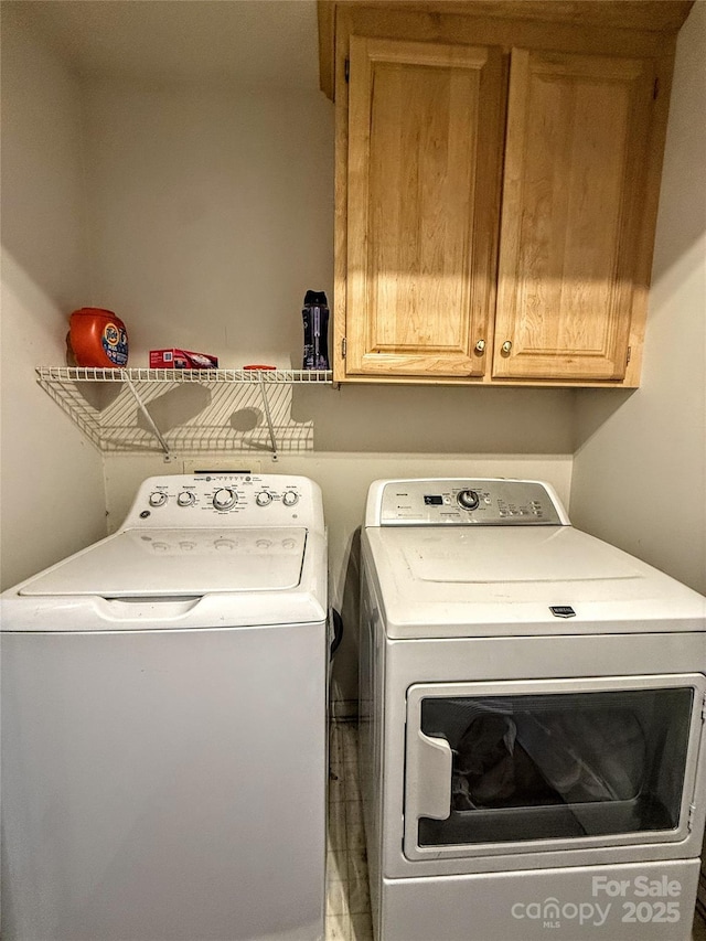 clothes washing area featuring cabinets and washing machine and dryer