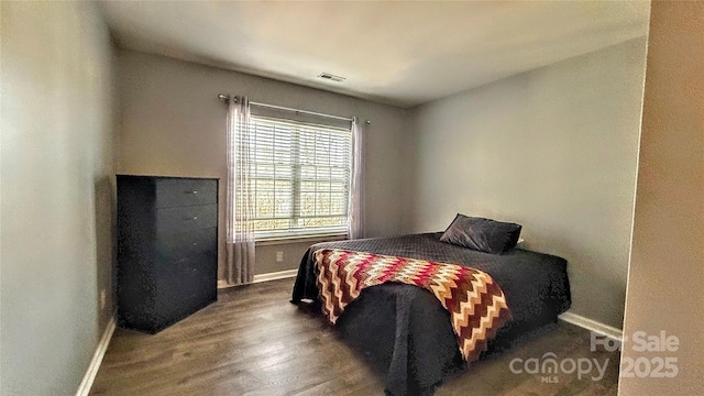 bedroom with dark hardwood / wood-style floors