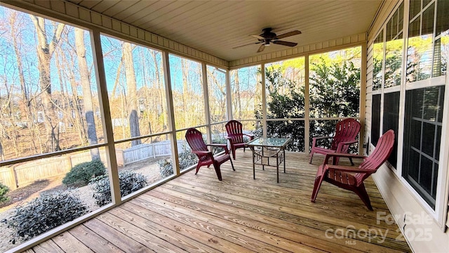 sunroom featuring a healthy amount of sunlight, wood ceiling, and ceiling fan