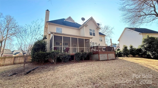 rear view of house featuring a yard, a deck, and a sunroom