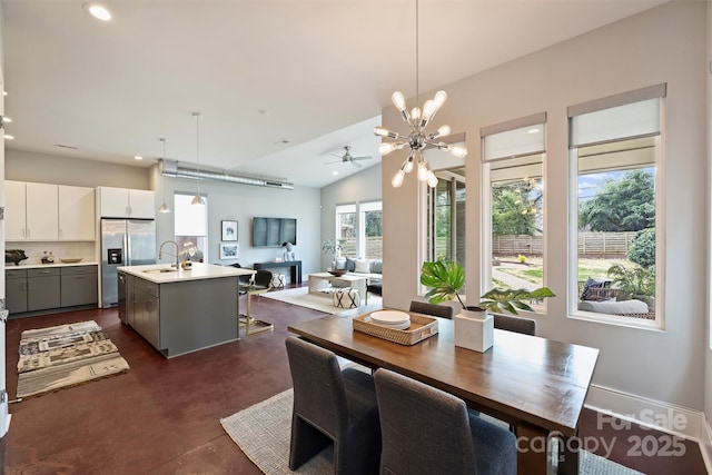 dining area featuring vaulted ceiling, a chandelier, and sink