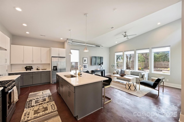 kitchen with appliances with stainless steel finishes, an island with sink, sink, gray cabinetry, and white cabinets