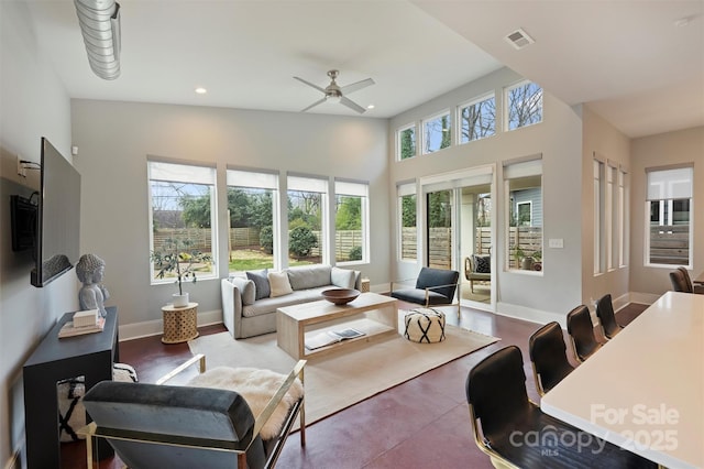 living room with ceiling fan and a high ceiling