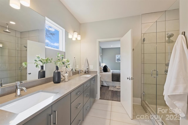 bathroom with an enclosed shower, vanity, and tile patterned floors