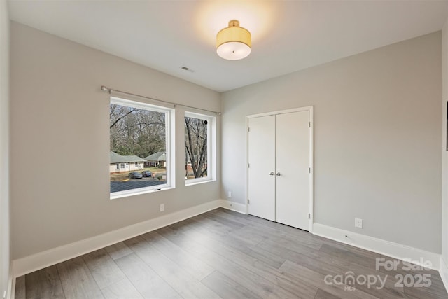 unfurnished bedroom with wood-type flooring and a closet