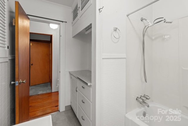 bathroom featuring shower / bathtub combination, vanity, and ornamental molding