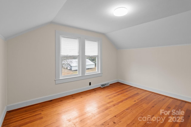 bonus room with wood-type flooring and vaulted ceiling