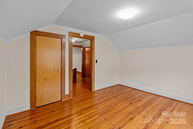 additional living space with vaulted ceiling and light hardwood / wood-style floors