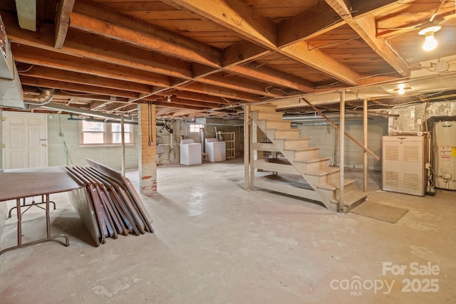 basement featuring water heater and washing machine and dryer