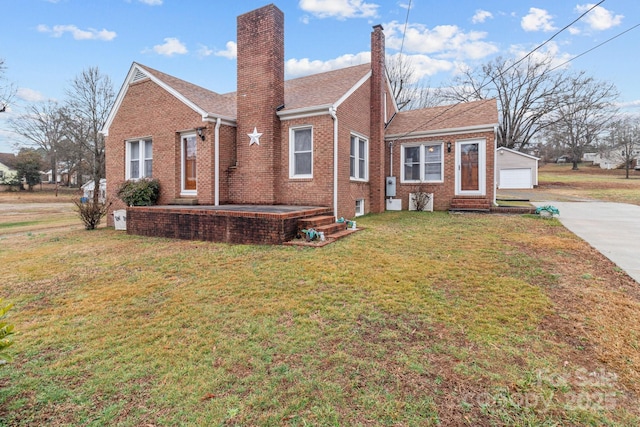 back of property featuring a garage, a yard, and an outdoor structure