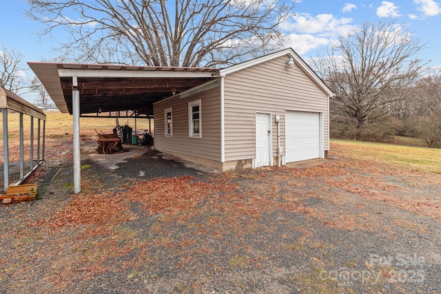 exterior space featuring a carport, a garage, and an outbuilding