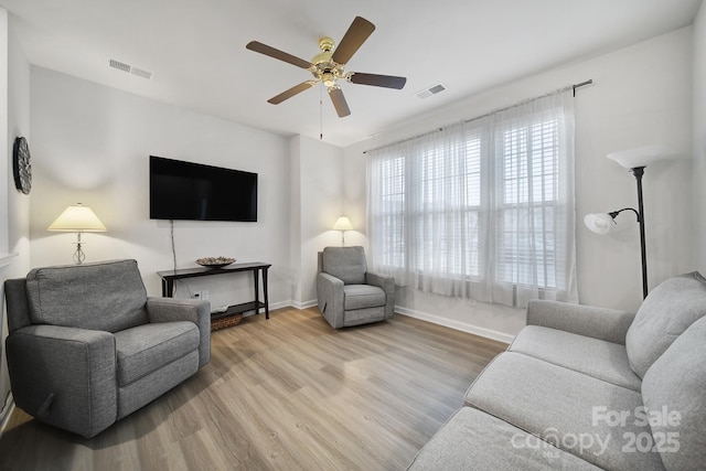 living room featuring ceiling fan and light hardwood / wood-style floors