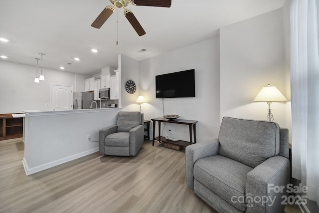 sitting room featuring ceiling fan and light hardwood / wood-style floors