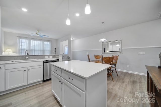 kitchen featuring a center island, decorative light fixtures, dishwasher, and white cabinets