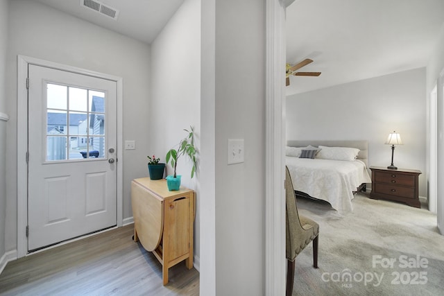 doorway with ceiling fan and light hardwood / wood-style flooring