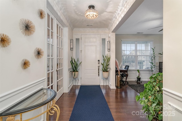 foyer entrance with dark hardwood / wood-style flooring and crown molding