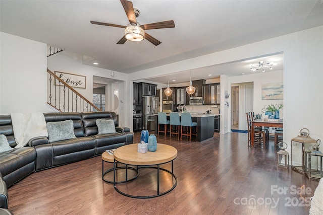 living room featuring ceiling fan and dark hardwood / wood-style flooring