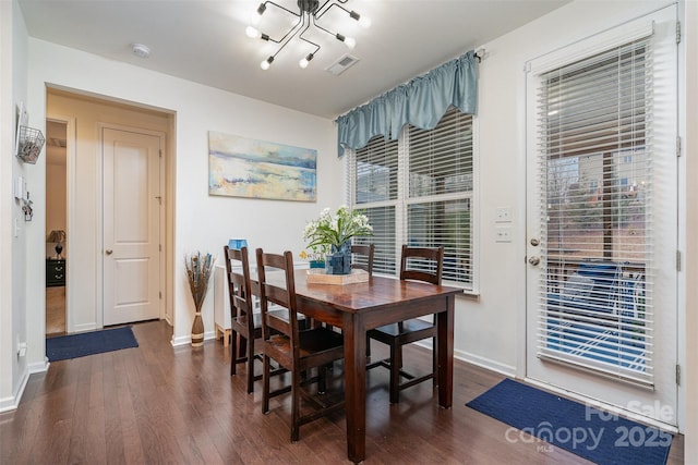 dining room featuring a notable chandelier and dark hardwood / wood-style flooring