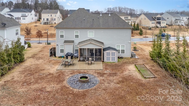 rear view of property featuring a fire pit, a sunroom, a patio, and central air condition unit