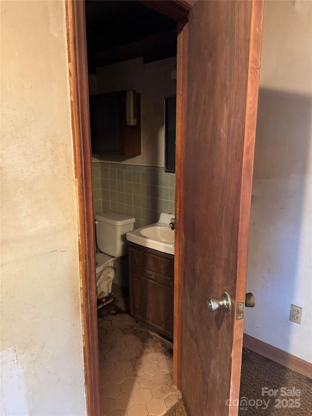 bathroom featuring tile walls, vanity, tile patterned flooring, and toilet