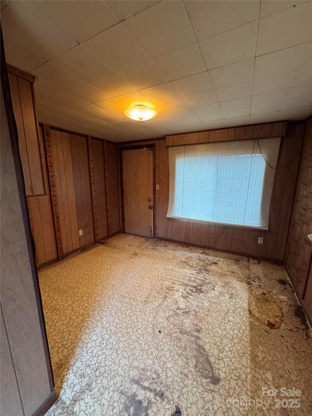 empty room featuring wood walls