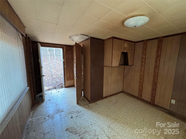 unfurnished room featuring wood walls