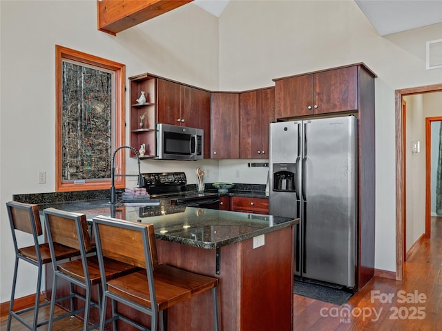 kitchen featuring dark wood-style flooring, open shelves, stainless steel appliances, a sink, and a peninsula