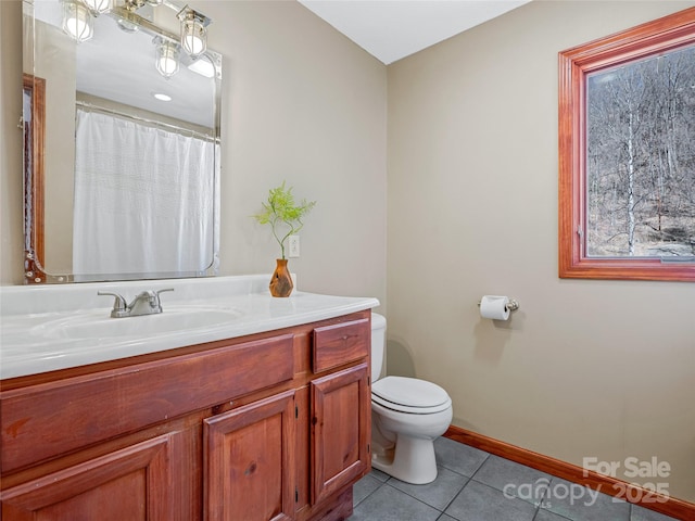 bathroom featuring toilet, vanity, baseboards, and tile patterned floors