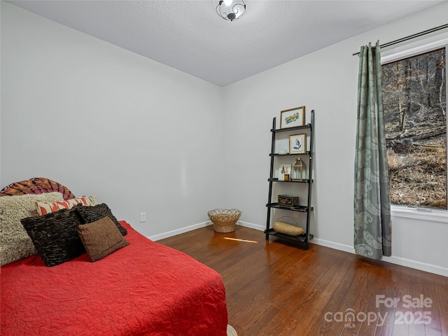 bedroom with baseboards and wood finished floors