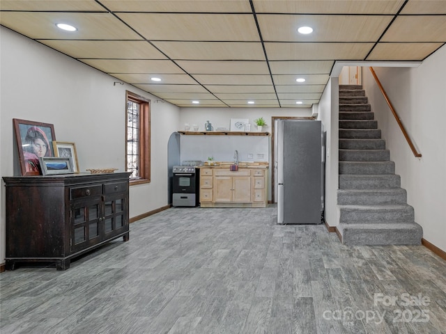 bar with baseboards, arched walkways, stairs, stainless steel appliances, and light wood-type flooring