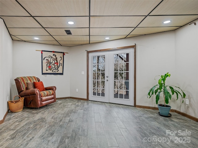 sitting room featuring visible vents, baseboards, wood finished floors, and french doors