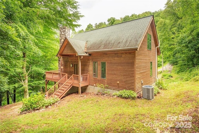 exterior space featuring roof with shingles, a chimney, central AC unit, a deck, and stairs