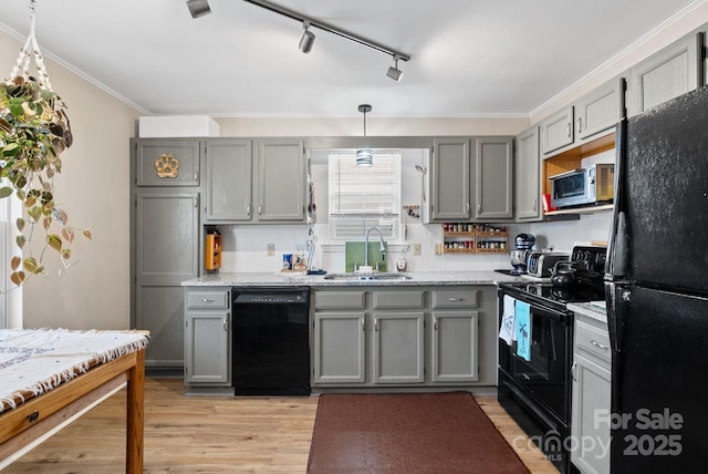 kitchen with black appliances, gray cabinets, a sink, and pendant lighting