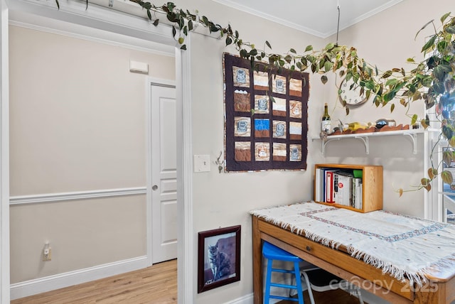 interior space with light wood finished floors, baseboards, and crown molding