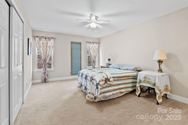 bedroom with a closet, light carpet, ceiling fan, and baseboards