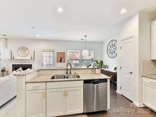 kitchen featuring sink, light stone counters, dishwasher, pendant lighting, and backsplash