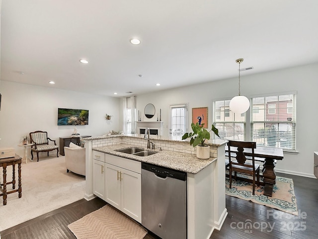 kitchen with dishwasher, sink, white cabinets, hanging light fixtures, and light stone countertops