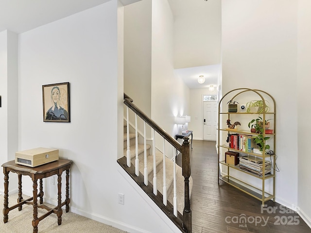 stairs with hardwood / wood-style flooring and a high ceiling