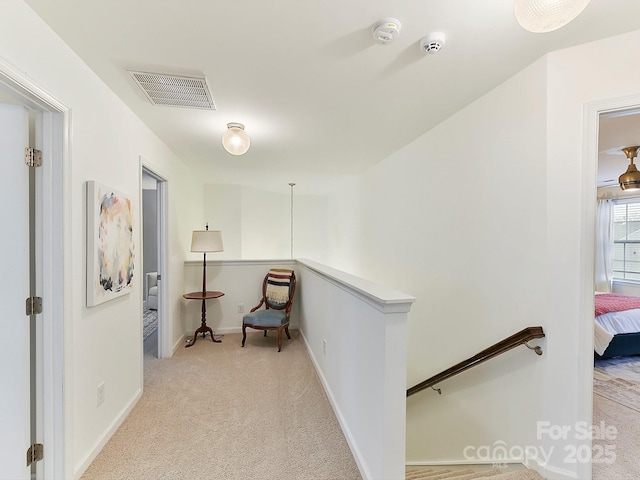 hall with light colored carpet