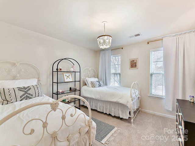 carpeted bedroom featuring an inviting chandelier and multiple windows