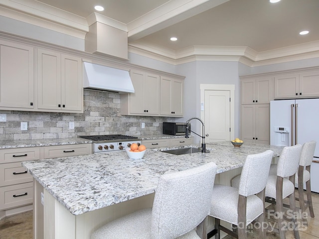 kitchen featuring light stone counters, custom exhaust hood, and a spacious island