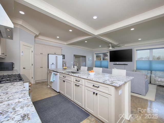 kitchen featuring sink, light stone countertops, a center island with sink, white appliances, and wall chimney exhaust hood