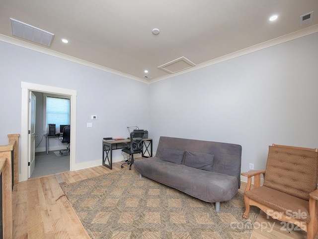 living area featuring wood-type flooring and ornamental molding