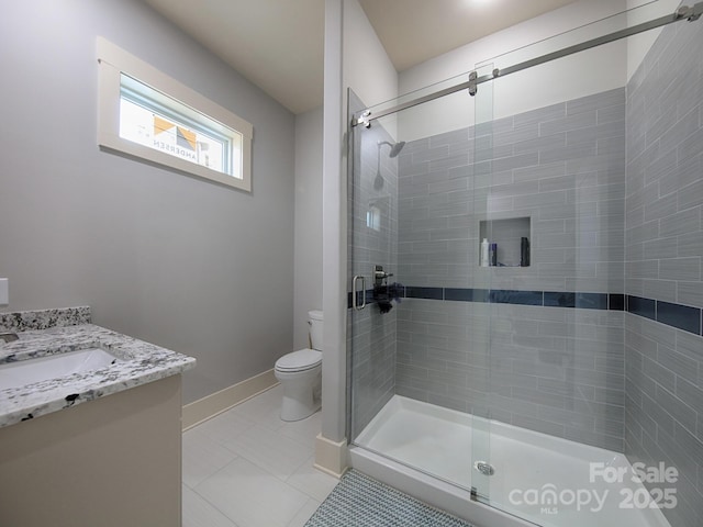 bathroom with vanity, toilet, a shower with shower door, and tile patterned flooring