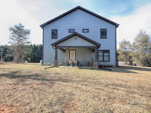 back of property with a yard and a patio