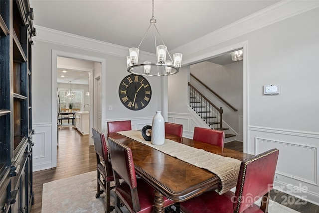 dining area with an inviting chandelier, dark hardwood / wood-style floors, and crown molding