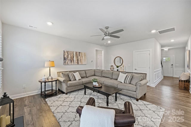 living room featuring ceiling fan and dark hardwood / wood-style floors