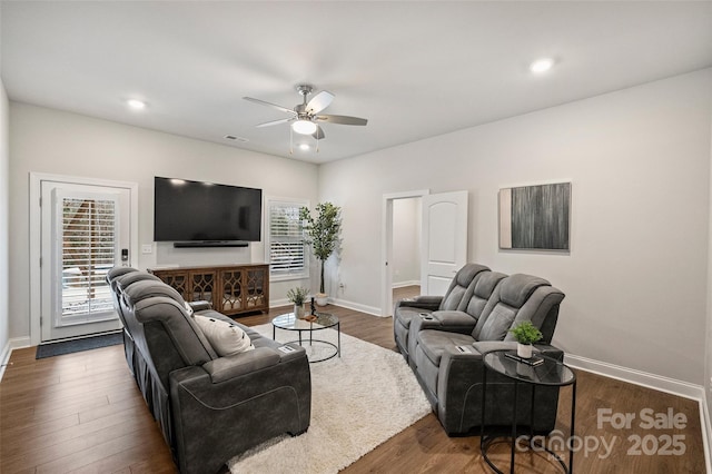 living room featuring ceiling fan and dark hardwood / wood-style flooring